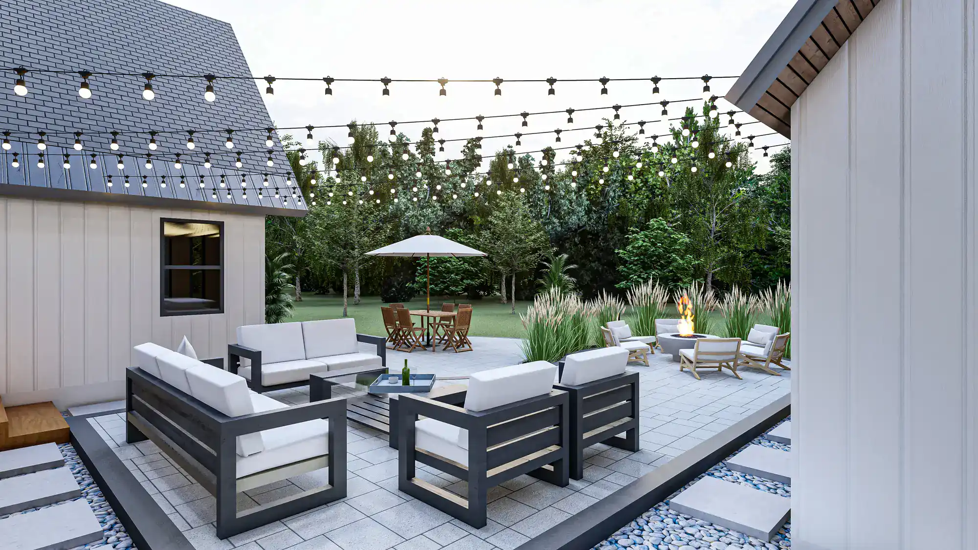 Modern backyard patio with string lights, outdoor sofas around a square fire pit, a dining table with umbrella in the grass, and lush green trees surrounding the space. Relaxed, inviting atmosphere for gatherings.